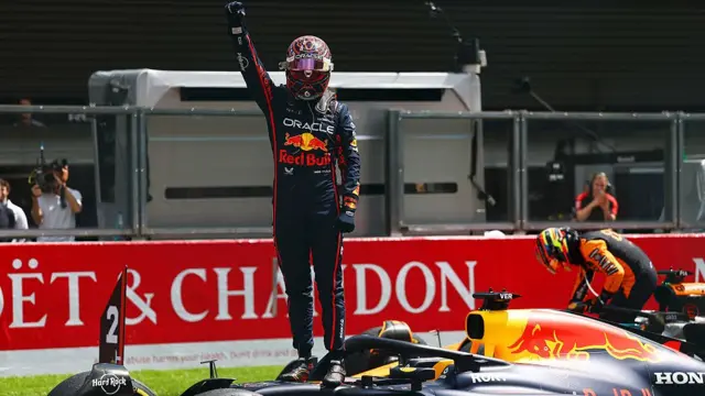 Max Verstappen celebrates winning the Sprint race by standing on his car at Spa