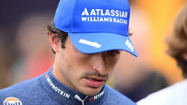 Carlos Sainz looks downcast in the paddock at Spa.