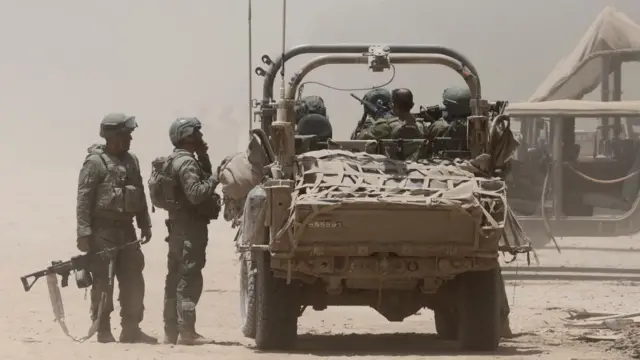 Israeli soldiers with a military vehicle at an undisclosed location near the border with the Gaza Strip