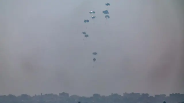 Humanitarian aid is airdropped over the northern part of the Gaza Strip. The aid is falling from the sky, with parachutes.