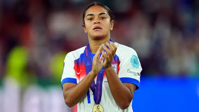 Jessica Carter of England acknowledges the fans while wearing her winners medal