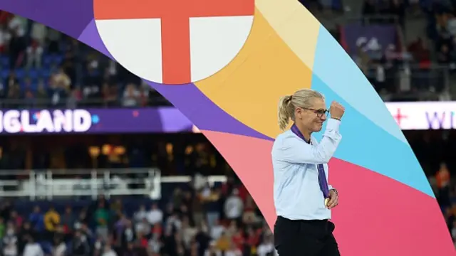 Sarina Wiegman, Head Coach of England, gestures while wearing her winners medal