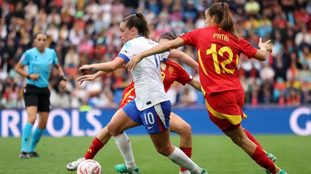 Ella Toone of England runs with the ball under pressure from Mariona Caldentey and Patricia Guijarro of Spain