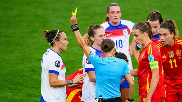 Referee Stéphanie Frappart (C) shows a yellow card to Lucy Bronze of England