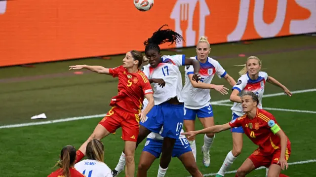 Spain's forward #09 Esther Gonzalez (L) and England's forward #17 Michelle Agyemang (C) go for a header