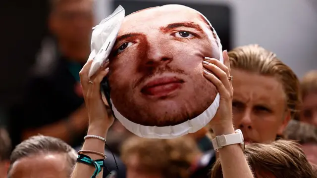 A cushion with Max Vertsappen's face on held aloft at Spa.