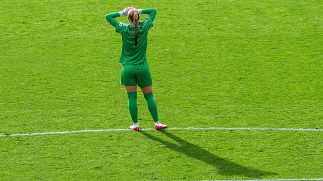 Hannah Hampton of England looks on as she shades the sun from her eyes