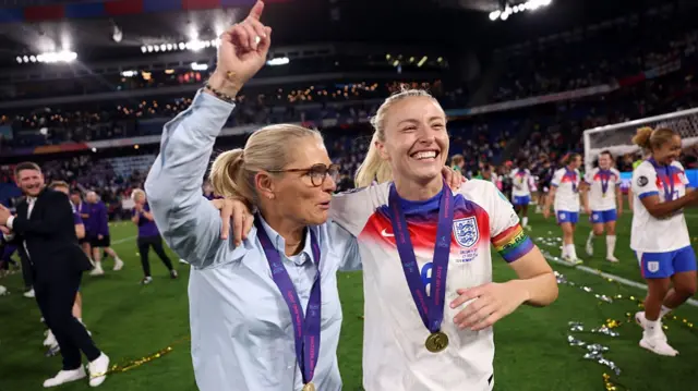 Sarina Wiegman, Head Coach of England, and Leah Williamson of England celebrate the teams victory, while wearing their winners medal