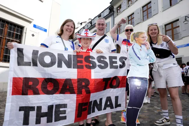 England fans with a flag reading 'Lionesses roar to the final'