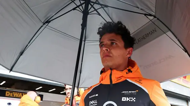 Lando Norris with an umbrella on the grid at Spa before the GP.