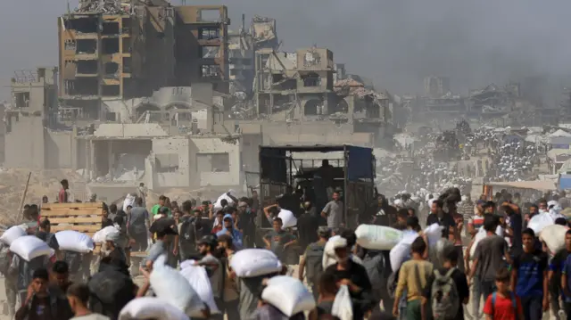 Palestinians carry aid supplies that entered Gaza through Israel,
