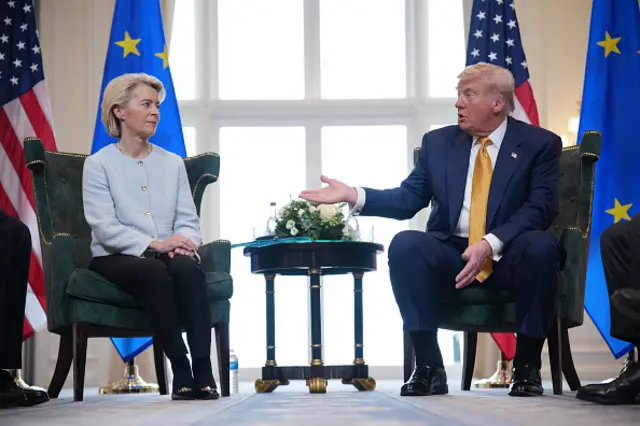 Donald Trump gestures towards Ursula von der Leyen as the two sit at a news conference in Ayrshire
