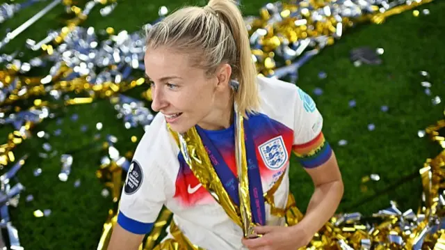 Leah Williamson of England sits in ticker tape as she celebrates following the teams victory