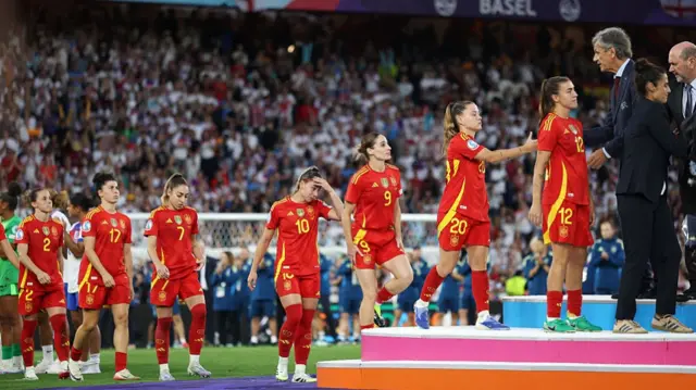 Claudia Pina of Spain prepares to shake the hand of Dominic Blanc, President of the Swiss Football Association, as she and her teammates collect their runners up medals