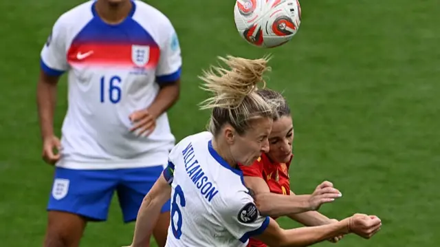 England's defender #06 Leah Williamson (C) and Spain's forward #09 Esther Gonzalez (R) go for a header