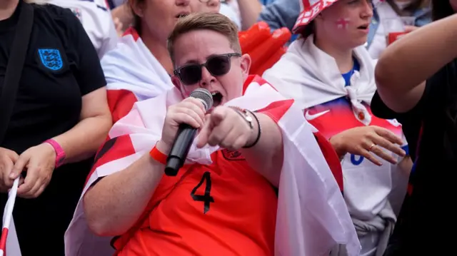 An England fan enjoys the pre-match atmosphere as they participate in the fan walk