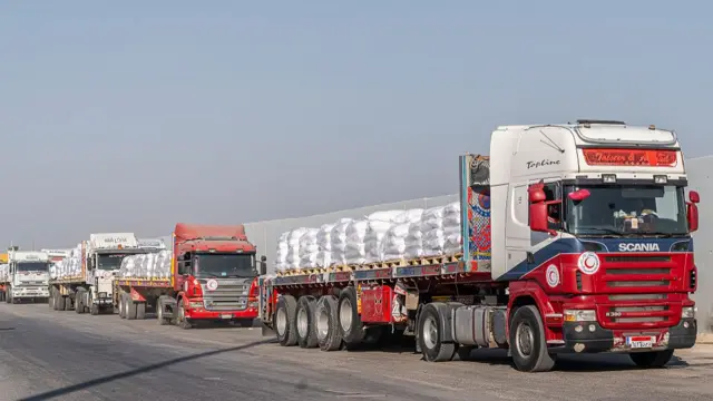 Trucks carrying aid queue up just off the Egyptian side of the Rafah crossing to the south of the Gaza Strip