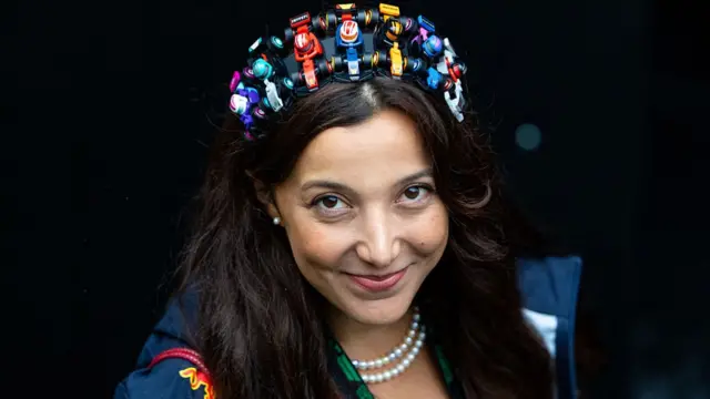 A fan wears a hat with toy F1 cars at Spa.
