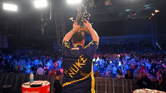 Luke Littler holds the UK Open trophy