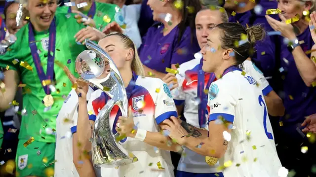 Chloe Kelly of England kisses the UEFA Women's EURO trophy before lifting after her team's victory