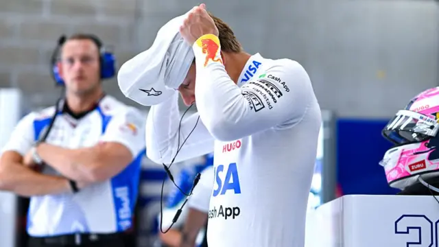 Liam Lawson suits up in the garage ahead of driving at the Belgian GP.