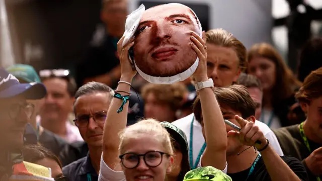 A fan holds aloft a Max Verstappen cushion at Spa.