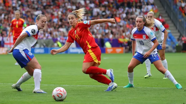 Alexia Putellas of Spain passes the ball under pressure from Kiera Walsh and Ella Toone of England