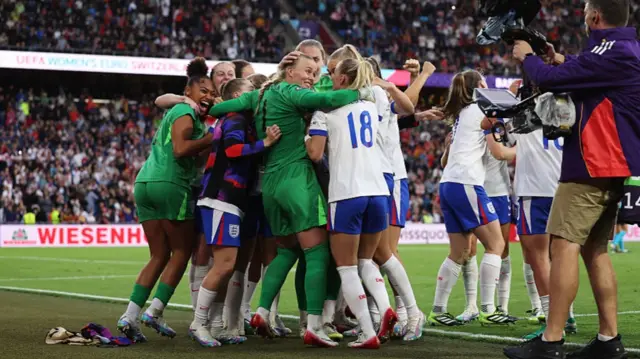 Hannah Hampton of England celebrates with teammate Chloe Kelly as they celebrate after Chloe Kelly of England (obscured) scores the team's winning penalty in the penalty shoot out