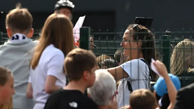 Former England player Jill Scott signs autographs for fans