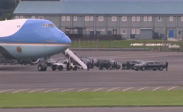 Air Force One on the tarmac surrounded by vehicles