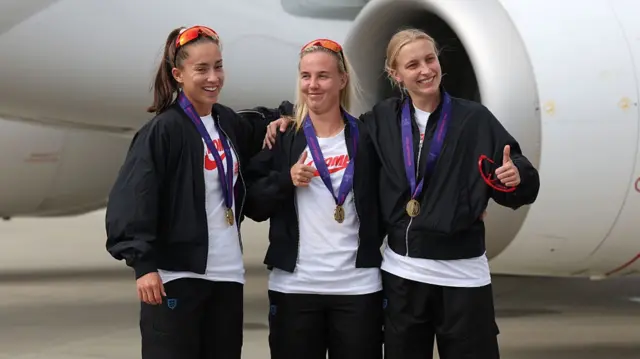 Maya Le Tissier, Beth Mead and Aggie Beever-Jones of England pose for a photo as they arrive at Southend Airport