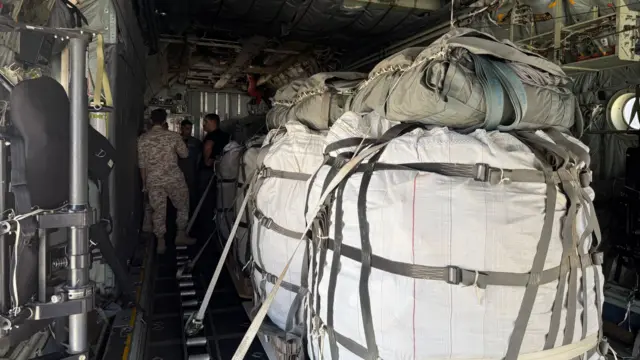 A close up of aid parcels loaded into a military plane