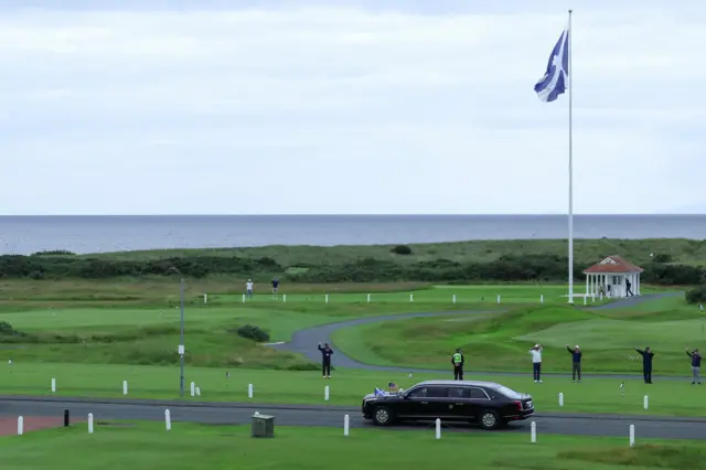 People waves as U.S. President Donald Trump's motorcade leaves Trump Turnberry golf course, in Turnberry, Scotland, Britain