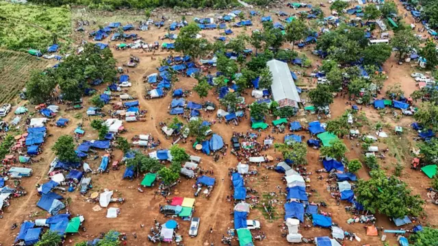 An aerial view shows people, who fled their homes near the border area between Cambodia and Thailand, taking shelter in dozens of blue tents in a part of Cambodia's Oddar Meanchey province