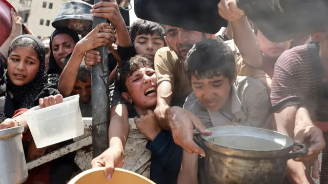 People wait for food in Gaza City