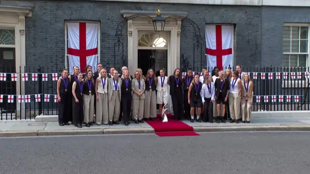 The Lionesses stand outside Downing Street wearing their medals