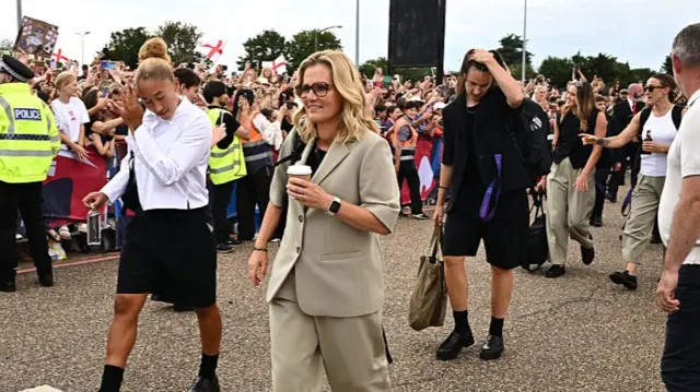Sarina Wiegman, Head Coach of England, greets fans after landing at Southend Airport on July 28, 2025 in Southend, England. England defeated Spain