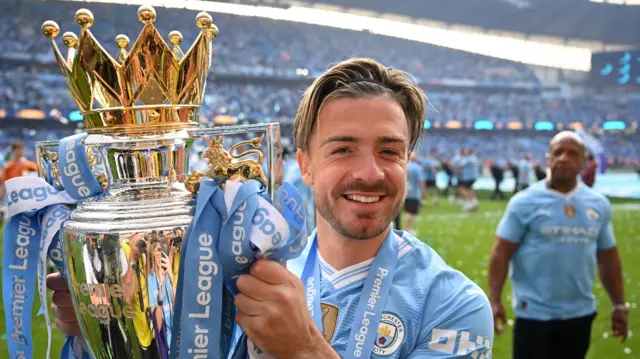 Jack Grealish holding the PL trophy