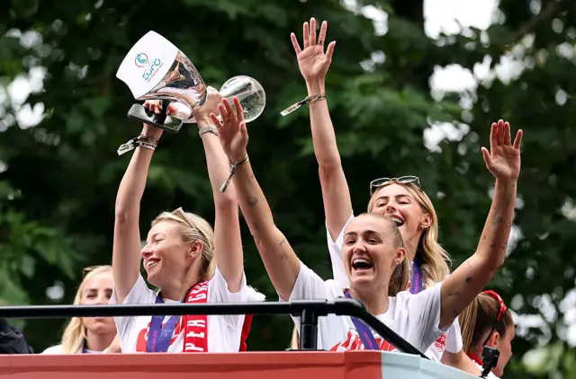 Leah Williamson lifting the trophy on the bus tour
