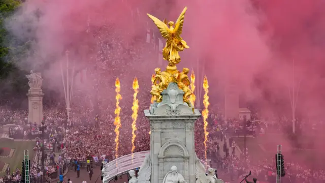 fans gather and flares go off during a Homecoming Victory Parade on the Mall, London. England