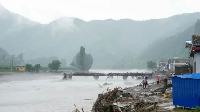 Floods have collapsed a bridge in Beijing's Huairou district, as residents take shelter