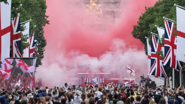 Pyrotechnics and smoke is seen down The Mall as England players celebrate with the fans during the victory celebrations