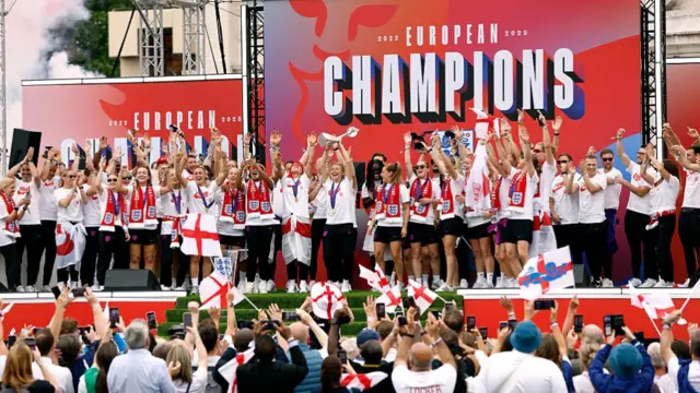 Leah Williamson of England lifts the UEFA Women's EURO trophy on stage during the England Women's team victory parade and celebration