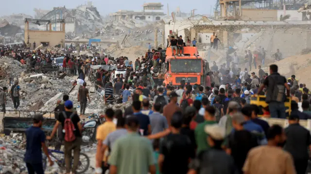 Palestinians gather around a truck carrying aid supplies that entered Gaza through Israel, in Beit Lahia, in the northern Gaza