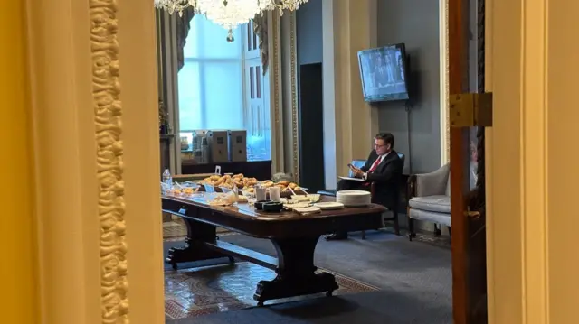 House Speaker Mike Johnson seated in a side room near the House floor at the US Capitol