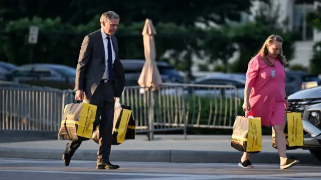 Republican Representative French Hill (L) and a staffer carry in an order of take away for voting sustenance