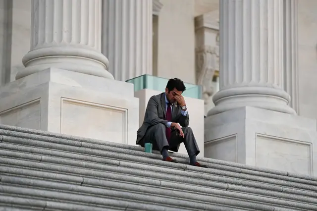 Democratic Representative Jimmy Gomez steals a quiet moment on the Capitol steps after spending all night at work