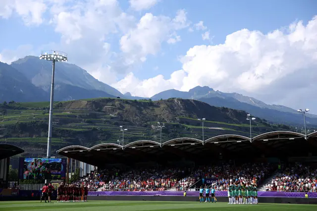 Players of Belgium and Italy pause for a moments silence