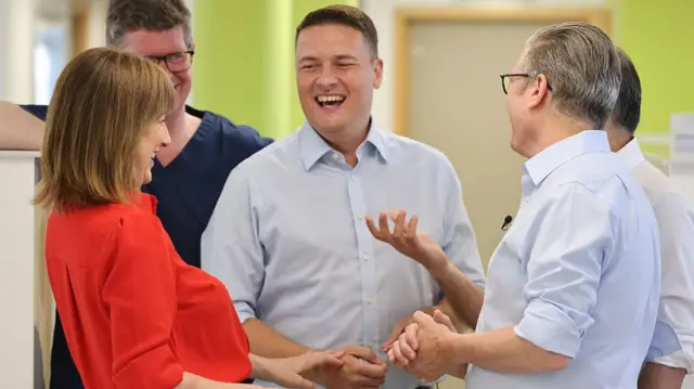 Rachel Reeves, Wes Streeting and Keir Starmer laugh at a hospital