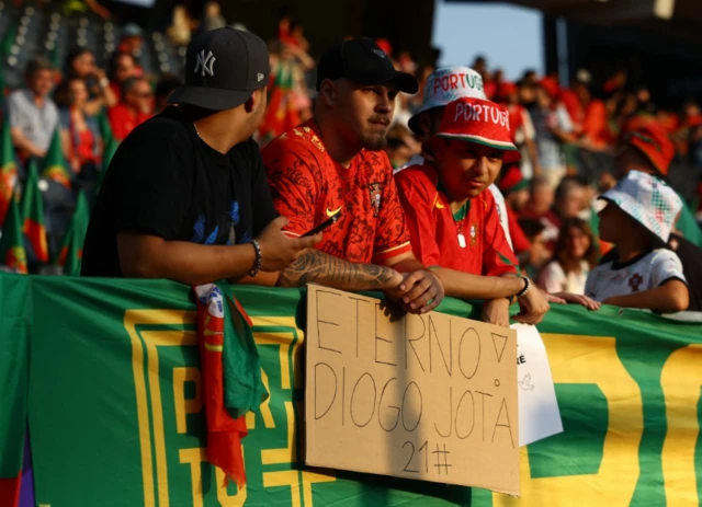 Portugal fans with a sign in memory of Diogo Jota